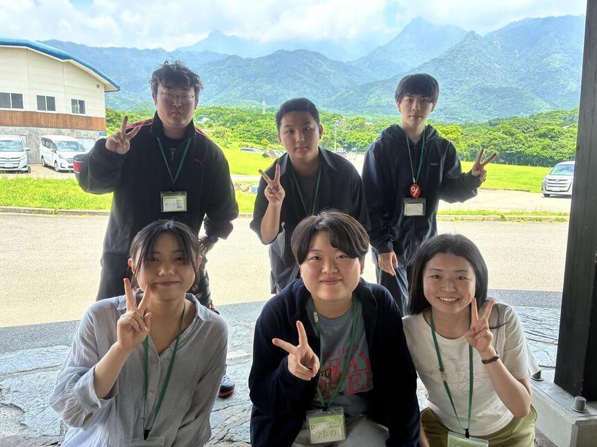 屋久島の自然を背景に、仙台キャンパスから一緒に参加したメンバーが笑顔をカメラに向けている様子