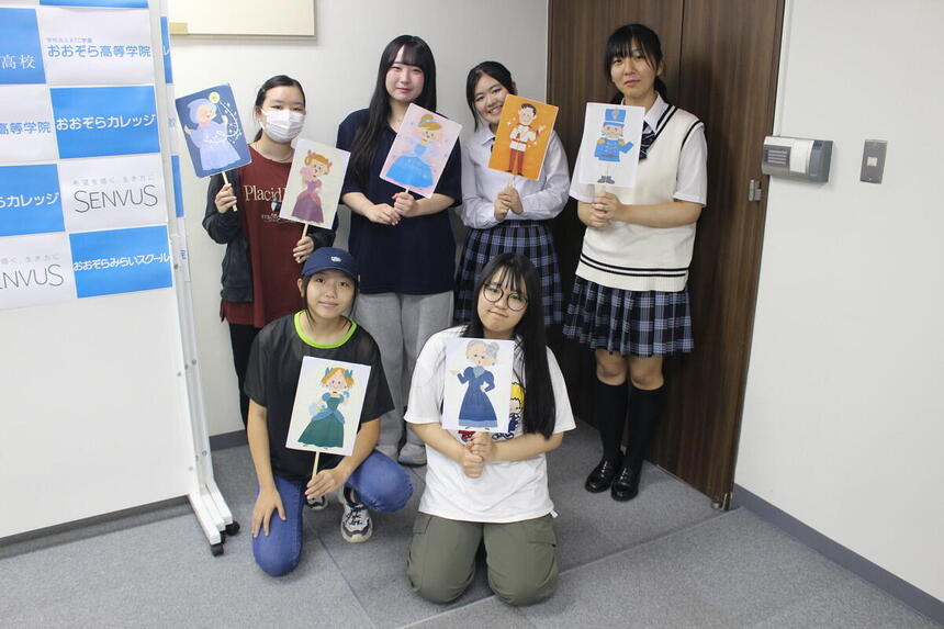 子ども・福祉コースの生徒らが、ペープサート劇で使用する小道具を手に写真に写る様子。