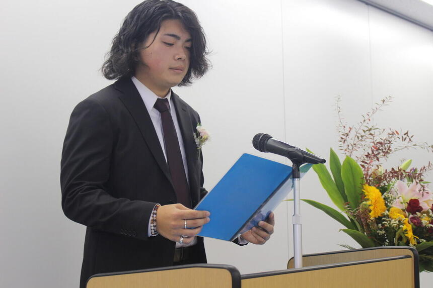 仙台キャンパスの卒業式で、卒業生代表のMくんが晴れやかな表情で答辞を読んでいる様子。