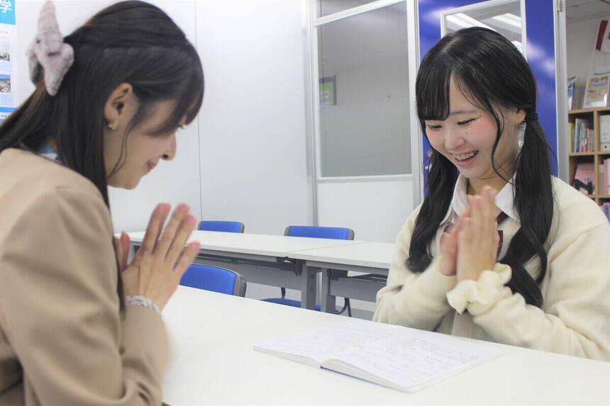 女子生徒が、KTCみらいノート®を真ん中にマイコーチ®と談笑する様子。
