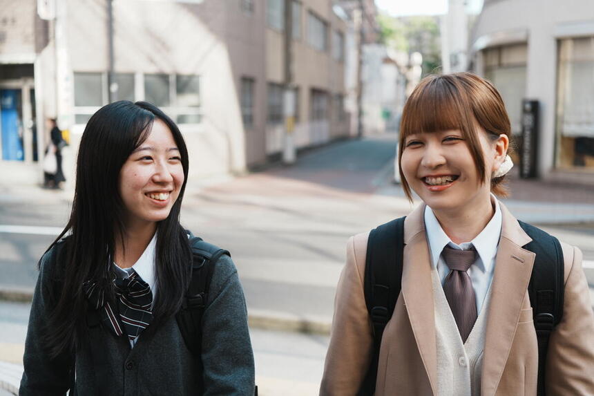 女子生徒二人が、おおぞら高校 仙台キャンパスに笑顔で登校する様子。