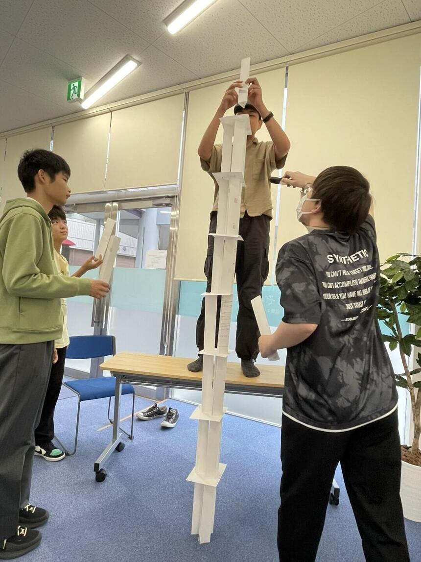 ペーパータワーを積み上げる生徒