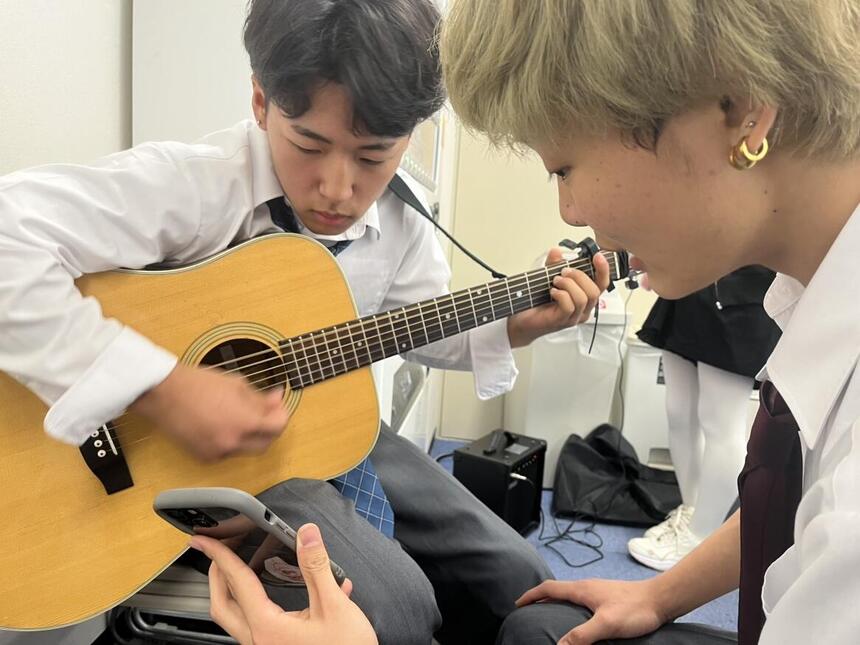 ギターを練習する男子高校生