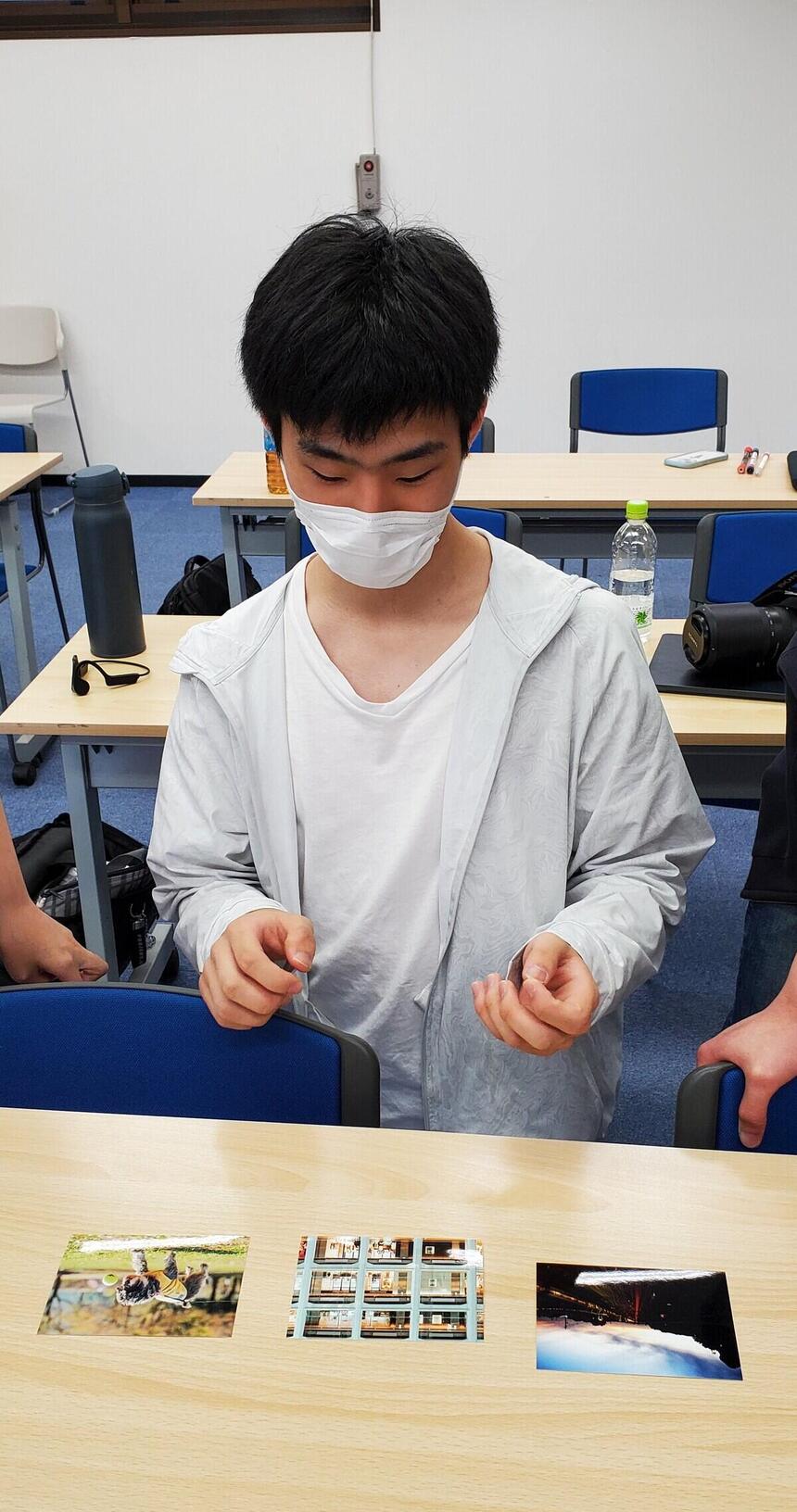 写真鑑賞する男子高校生