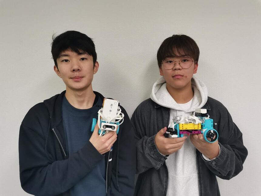 プログラミングロボットを持つ男子高校生二人組