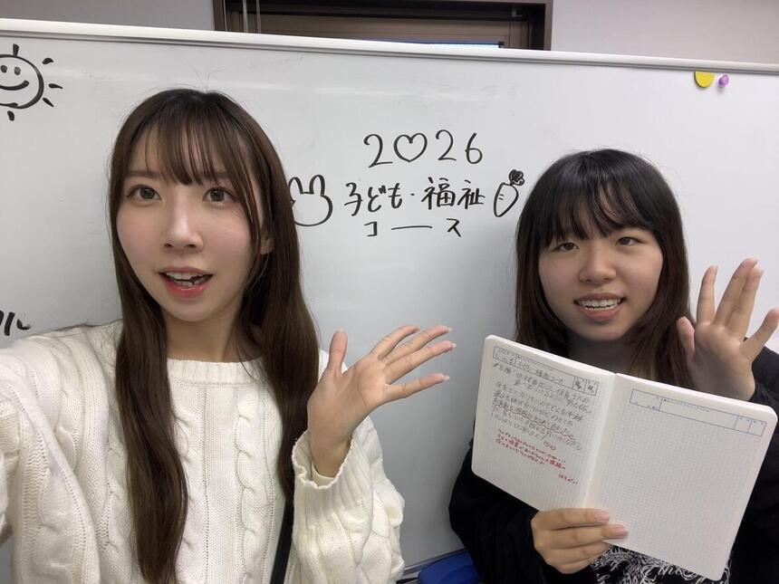 子ども・福祉コースの生徒とコーチがみらいノート®を笑顔で持っている様子