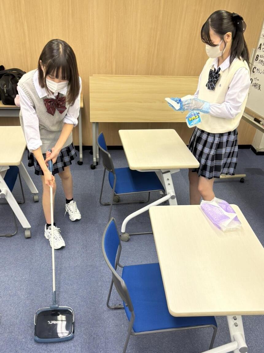 2人の女子生徒が教室を掃除している様子