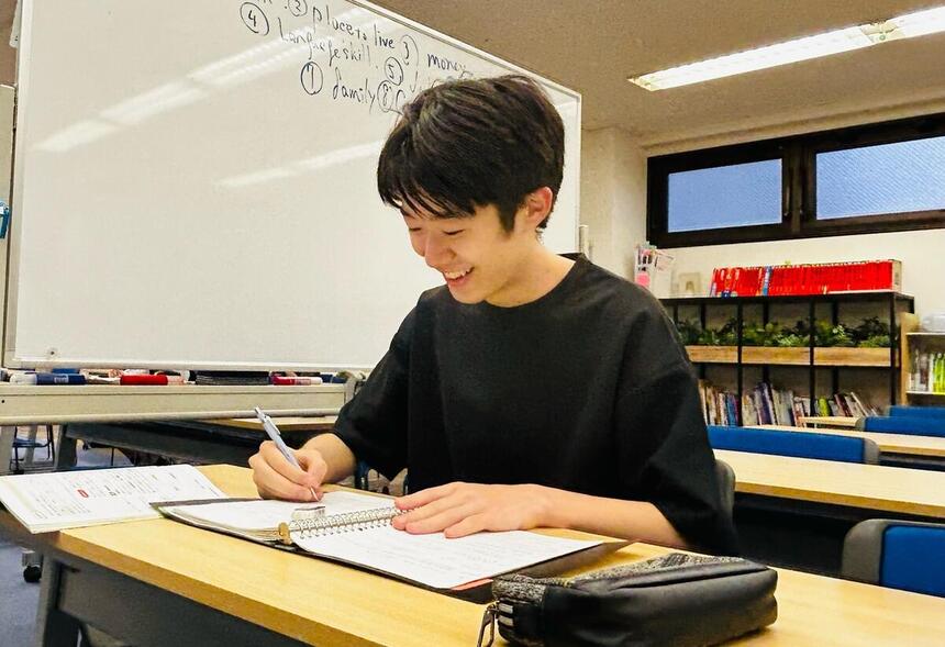 教室でノートを取っているT君