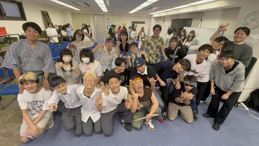 イベントに参加した生徒たちが教室に集合して笑顔で肩を組んだりポーズをとったりしている写真
