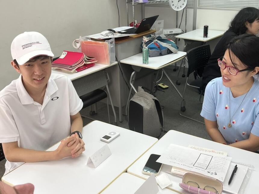 外国人の女性と日本人の男性が楽しそうに談笑する画像