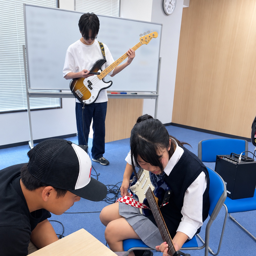 生徒が教室で音楽サークルに参加していてギターを弾いたり教えたりしている様子