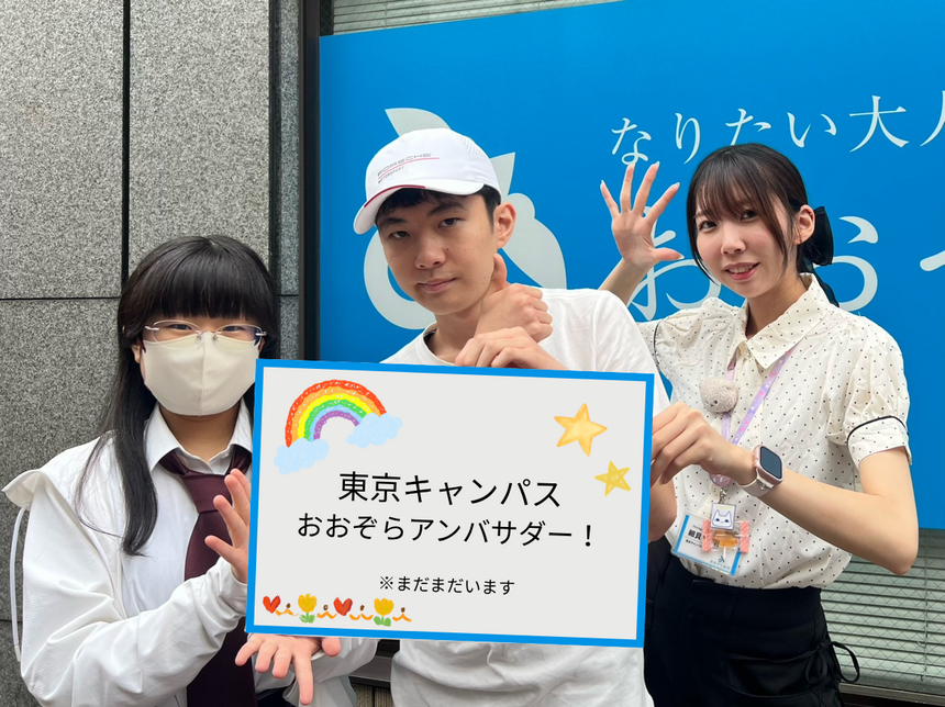 生徒2人とコーチが「東京キャンパスおおぞらアンバサダー！」と書かれたボードを笑顔で持っている様子