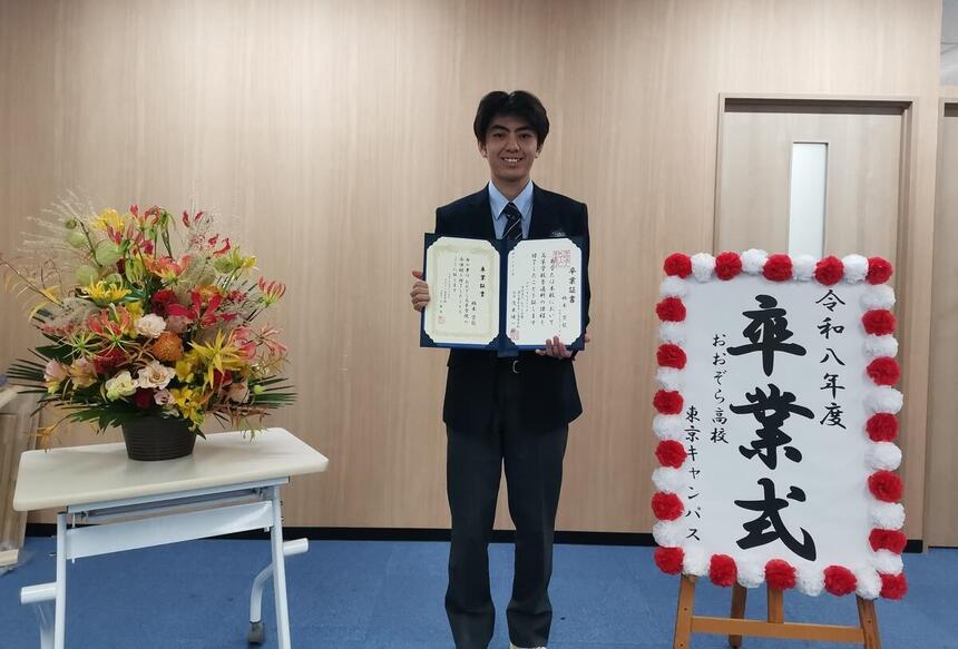 教室を背景に卒業証書を持ちながらポーズをきめている生徒写真
