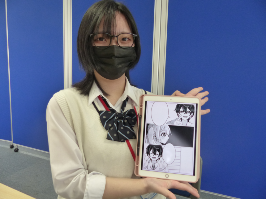 キャンパスでマンガイラスト在籍生が自分で書いたマンガを持っている写真