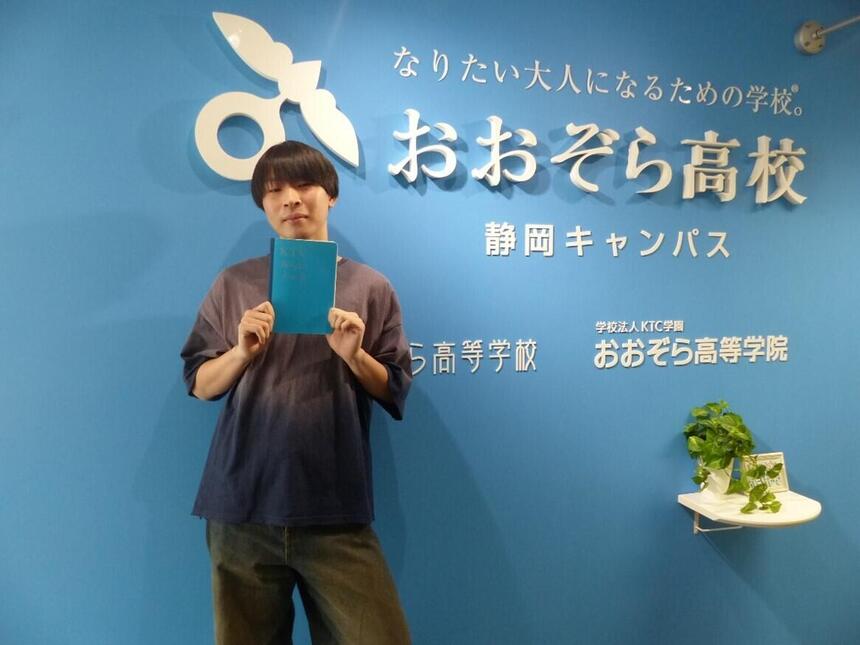 静岡キャンパスの入り口で男子生徒がみらいノート®を持っている