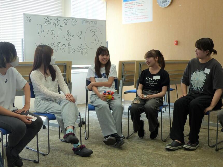 みらいの架け橋レッスン®にて討論テーマについて考え話している女子生徒と話を聞いている周りの生徒