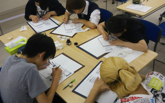 ペン入れの作業に熱中している生徒たち