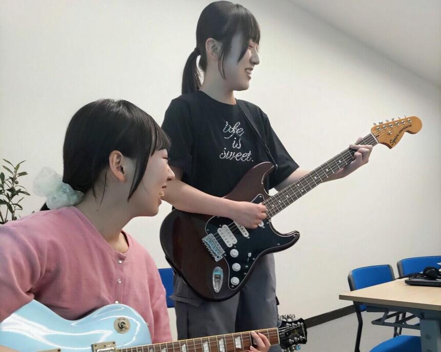 ギターを弾く生徒