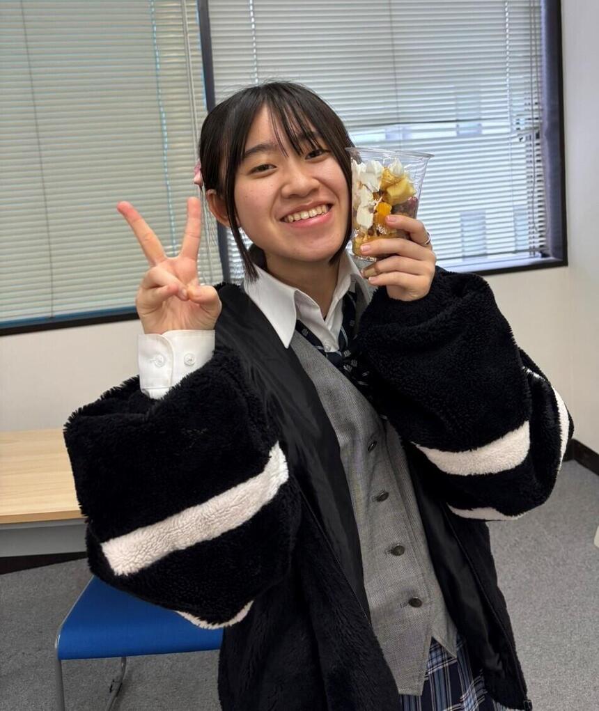 カップケーキを片手に笑顔の生徒