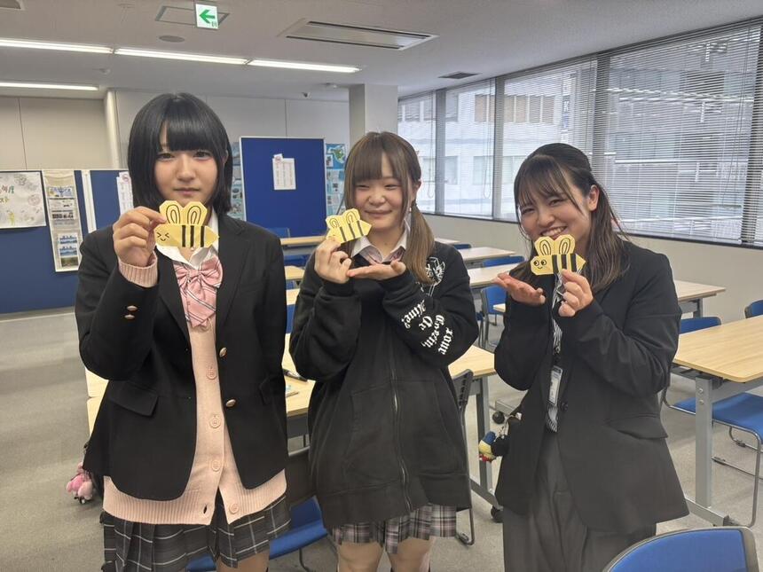 みつばちの折り紙を持つ笑顔の生徒＆コーチ