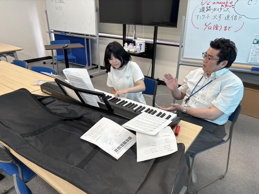 コーチとピアノレッスンに励む真剣な眼差しの生徒