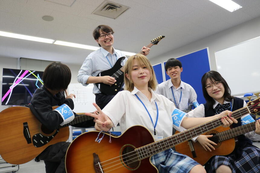 中学生とのギターレッスンに参加した在校生・コーチの笑顔の集合写真