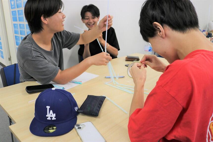 教室で仲間と協力してストロータワー作りに挑戦する生徒