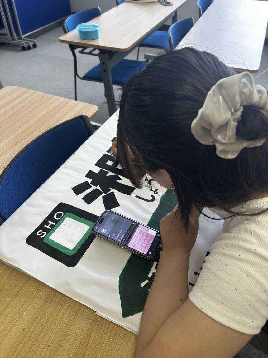 教室で江ノ電ブースの掲示作成に一生懸命取り組む生徒
