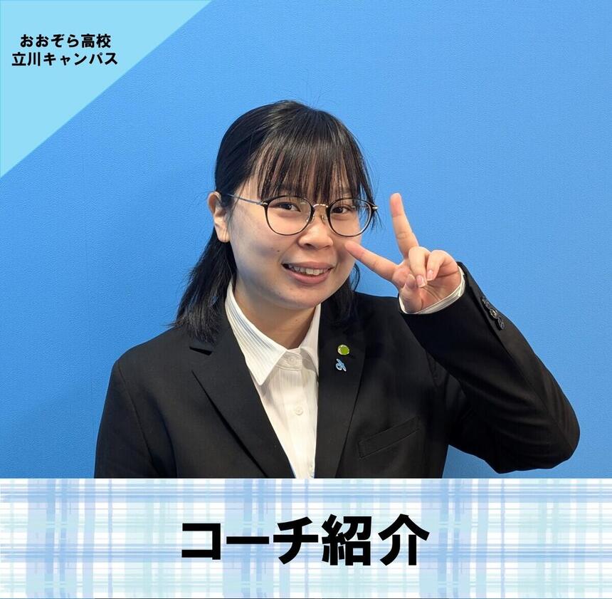 小林コーチが青い壁の前で笑っている写真