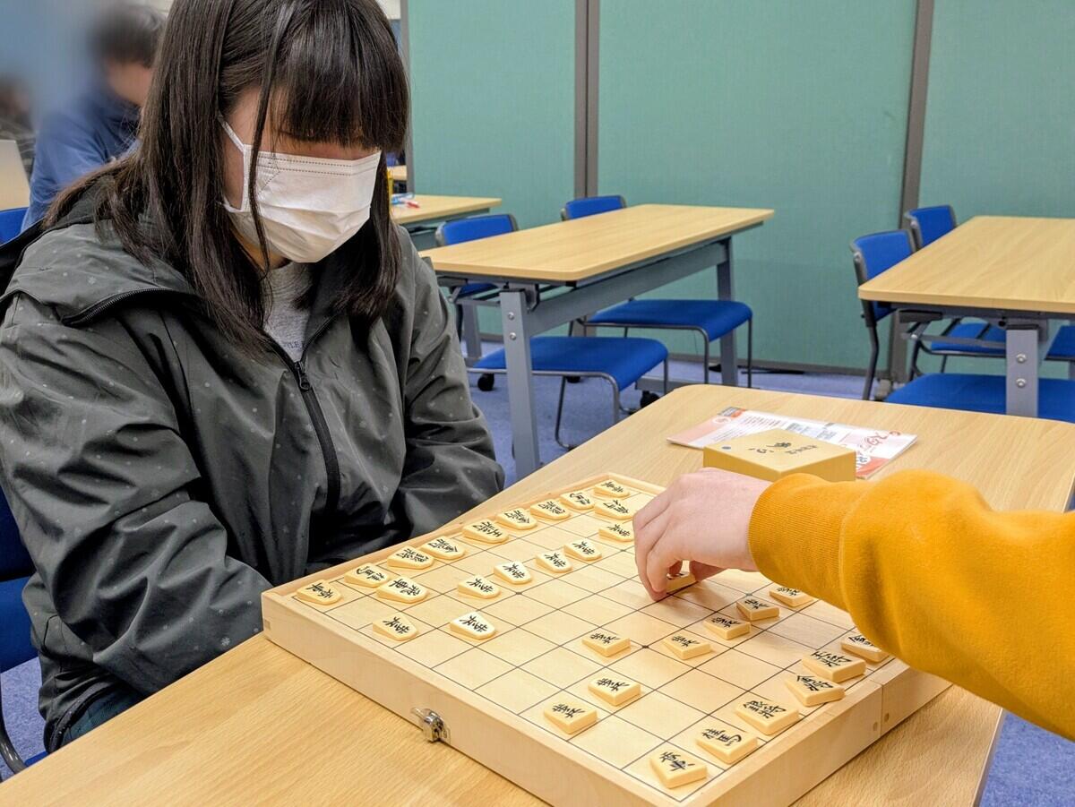 将棋盤をじっくり見つめている生徒