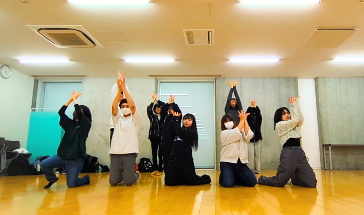 「花が咲く」ポーズをしている生徒