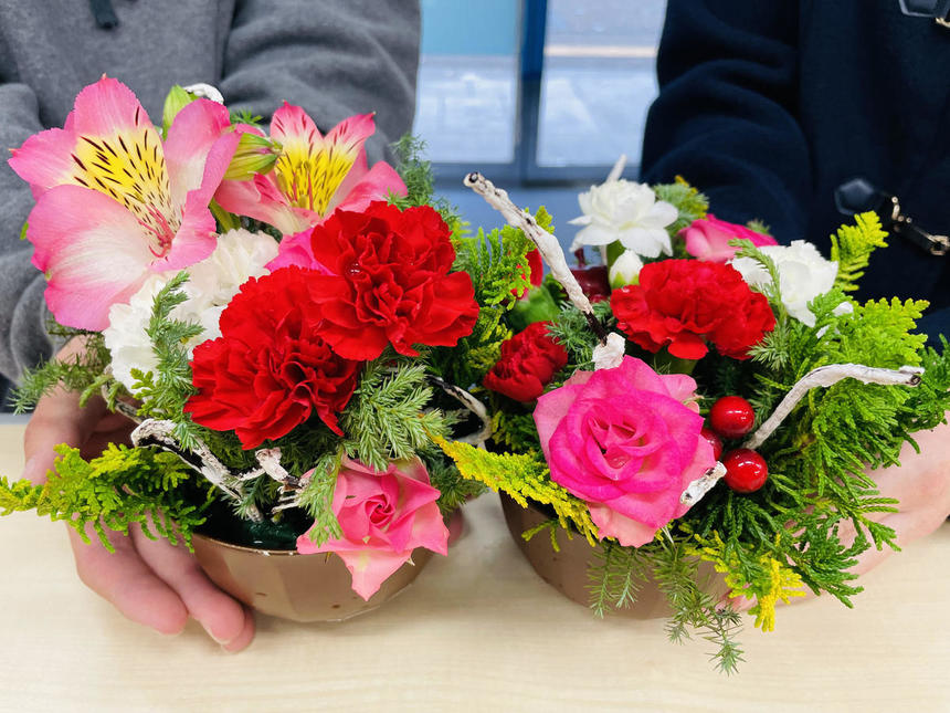 ２つの小さなカップに植えられた赤やピンクの花