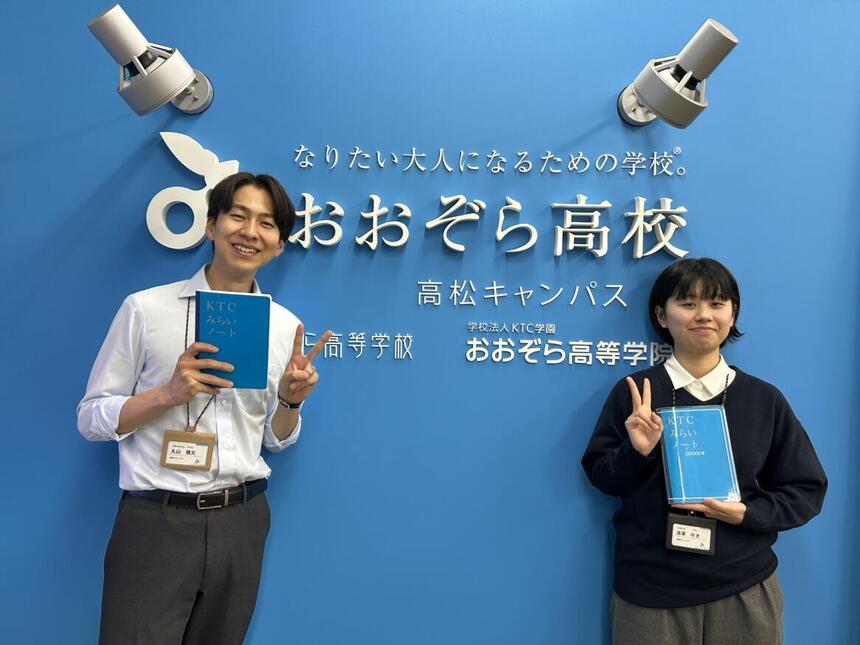 二人の新スタッフがKTCみらいノート®を持って笑顔で写っている写真