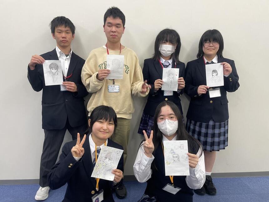 マンガイラストコースの生徒がそれぞれの作品を持って写っている写真