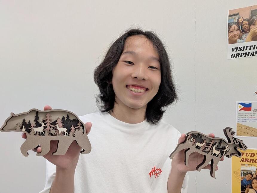 国内留学参加生徒が留学先のお土産を持って笑顔を見せている写真