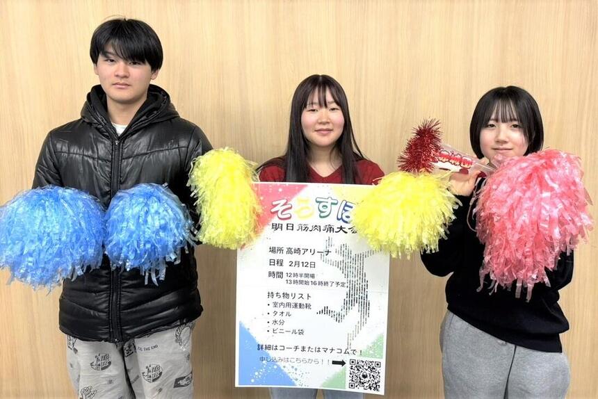 高崎キャンパス体育祭（そらスポ～明日筋肉痛大会）の案内を持つ3人の生徒