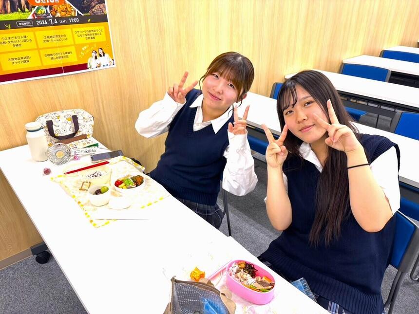 高崎キャンパスの教室でお昼休みに手作りのお弁当を食べる女子生徒2人