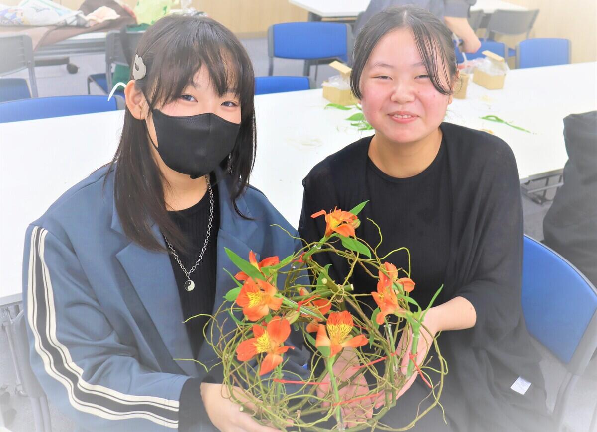 フラワーアレンジメントを持った生徒
