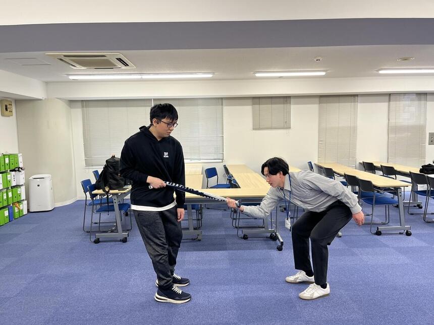 コーチと生徒でタオル相撲をする様子