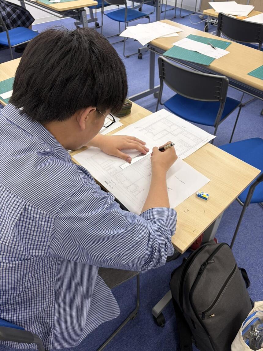 生徒が授業で図面の記入をしている様子
