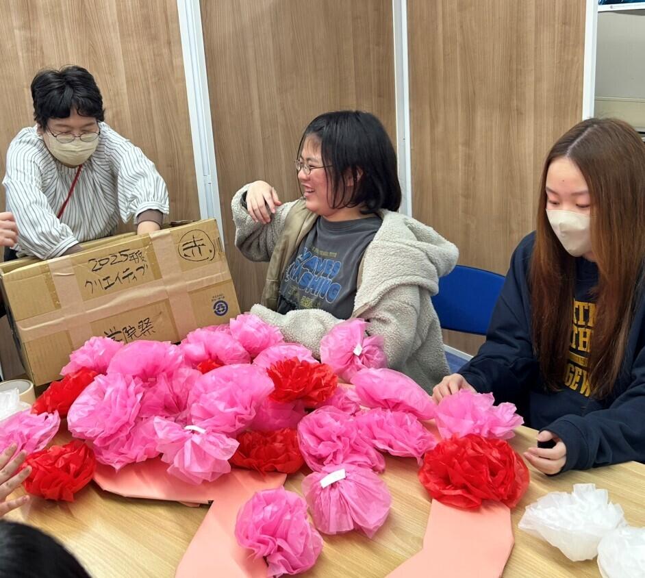 紙でお花を作ってフォトブースを作っている生徒