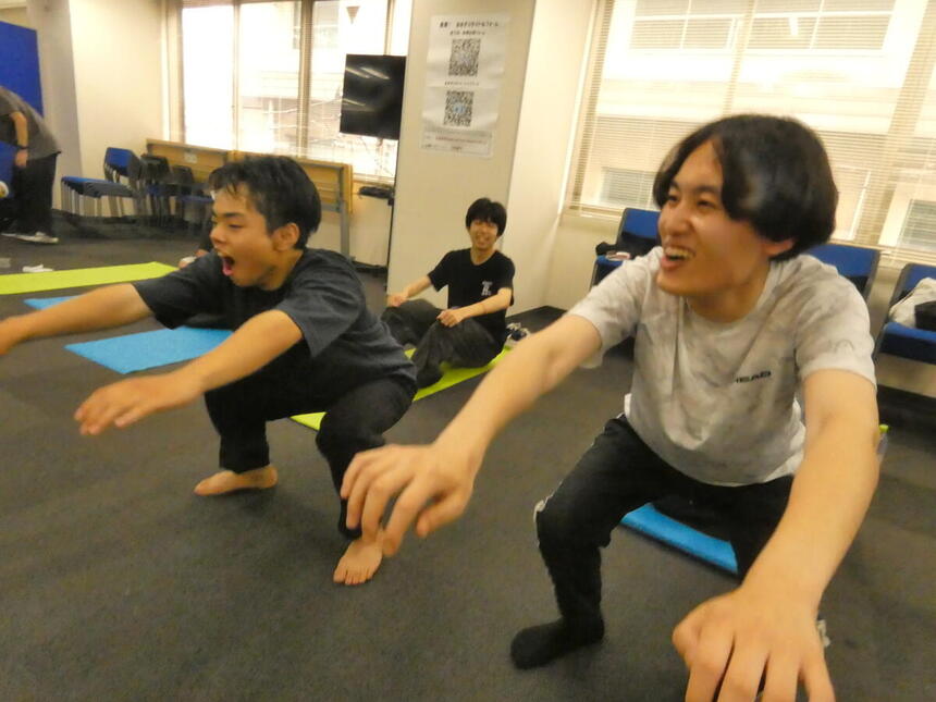 みらいの架け橋レッスン®中、キャンパス内で、生徒とコーチが並んでスクワットをしています。
