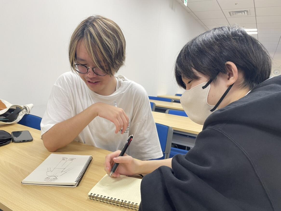 キャラクターデザインをどうするか話し合っている生徒