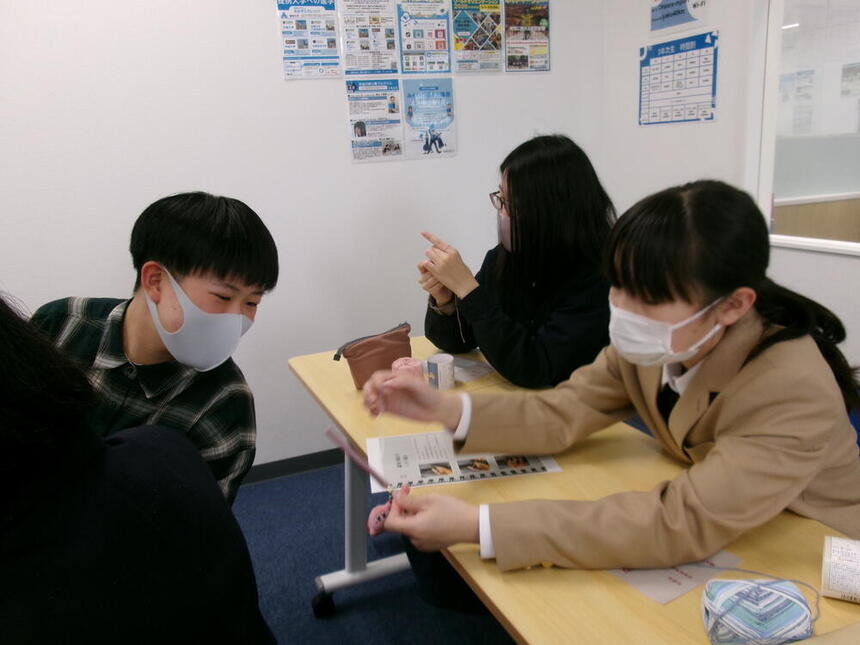和歌山キャンパスの教室で編み物を教えあっている1年生の様子