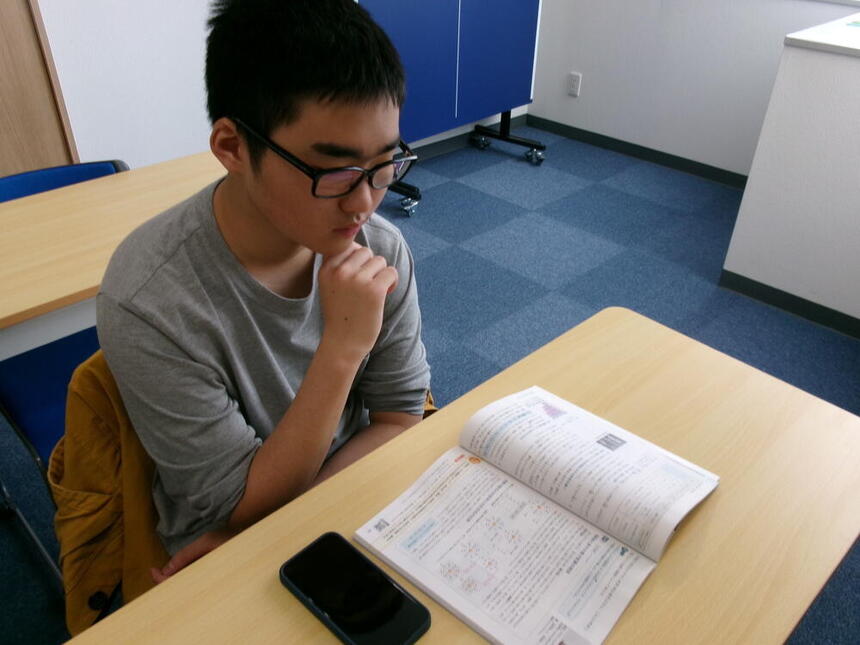 個別指導コースの生徒が、教科書を見ながらレポートを解き進めている様子。