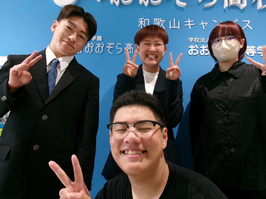 和歌山キャンパスの4人の生徒が笑顔でピースをしている様子
