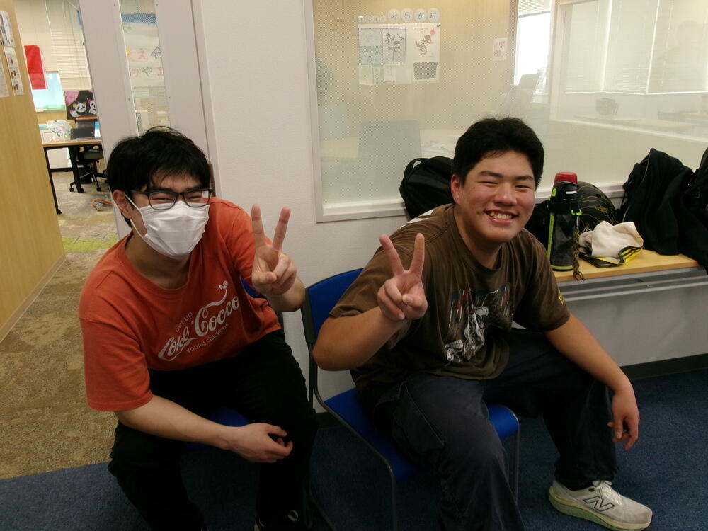 笑顔でピースをする男子生徒