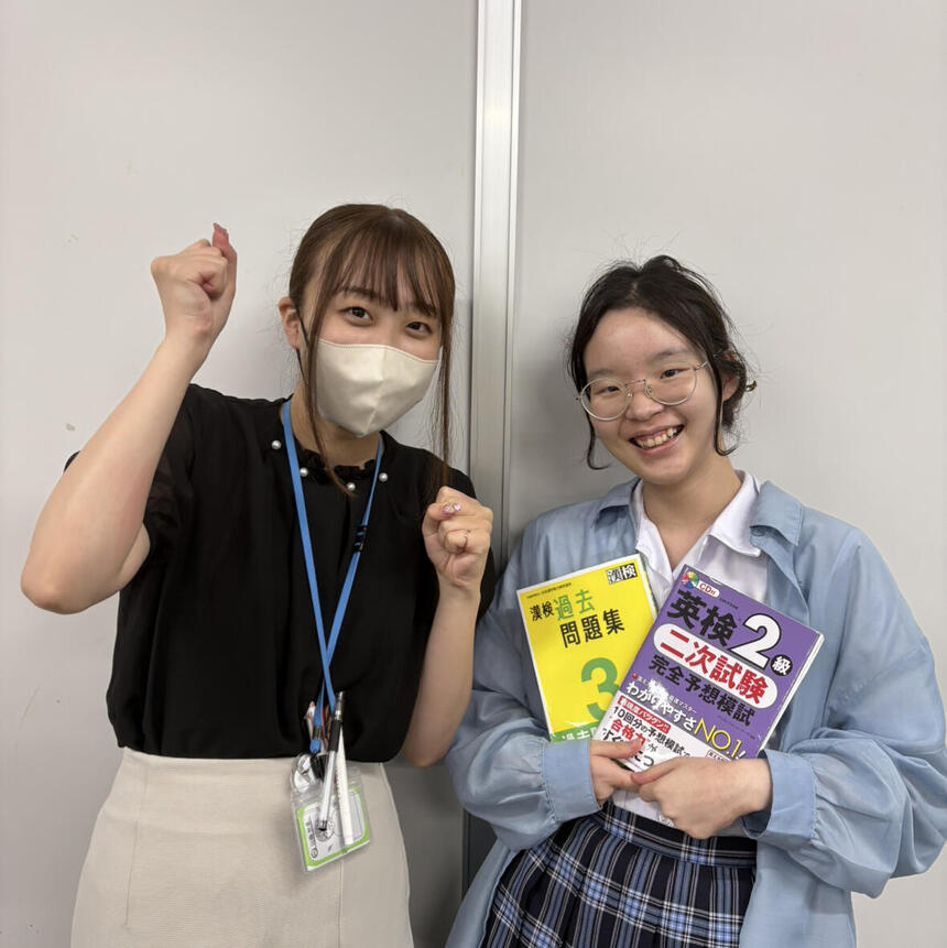 検定の問題集を持つ生徒とコーチ