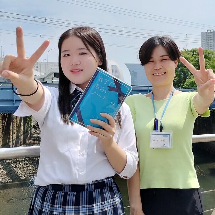 ピースサインをしている真奈美さんとンバイコーチ