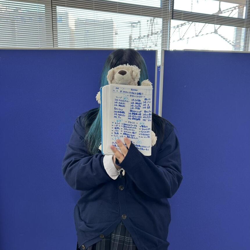 顔を隠してみらいノートを持っている生徒